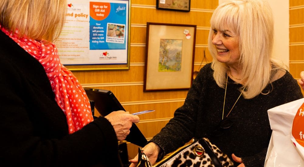 Summertown woman volunteer smiling with customer_1000x550 Summertown woman volunteer smiling with customer