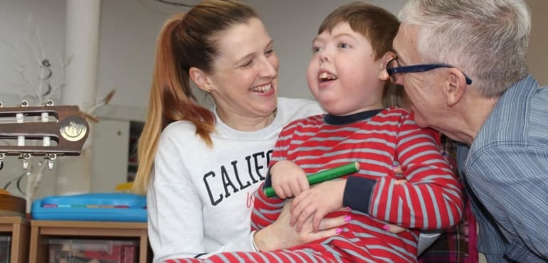 Little boy with parents smiling at hospice