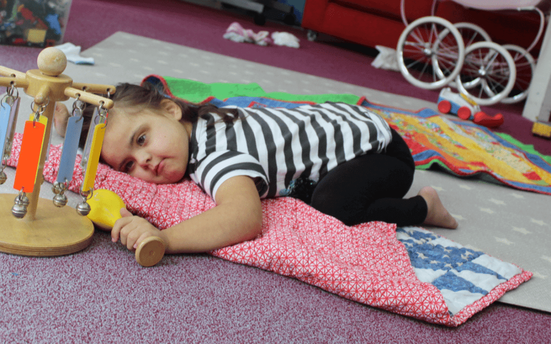 Little girl playing on the floor at Helen & Douglas House