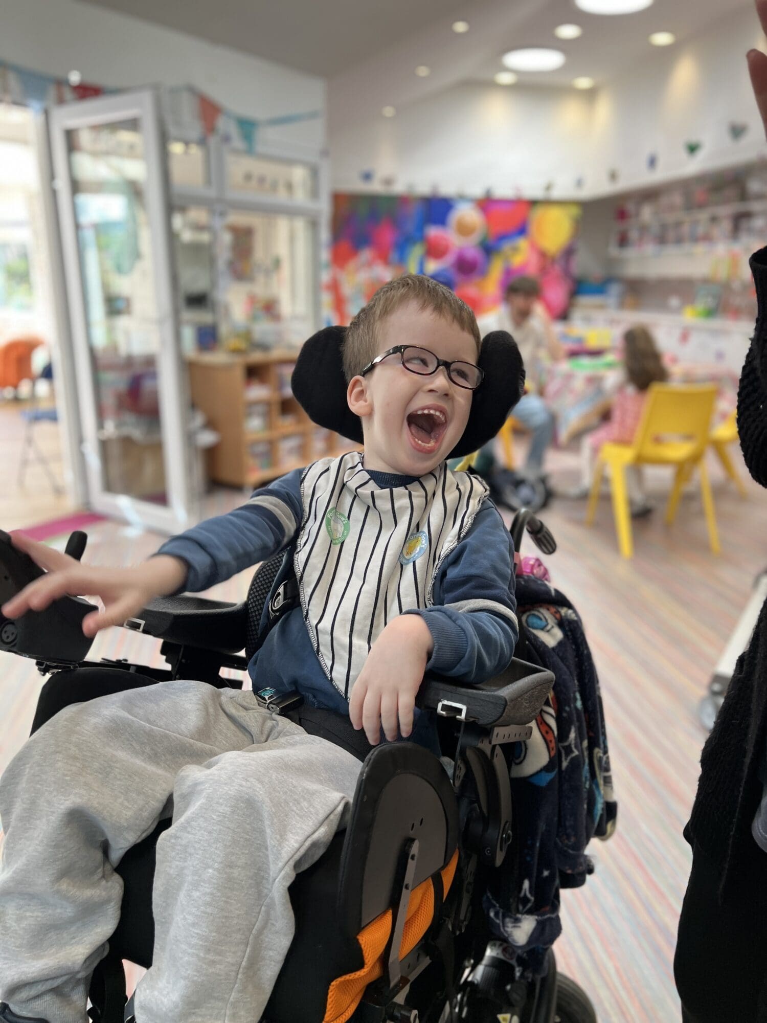 a little boy smiling in a wheelchair