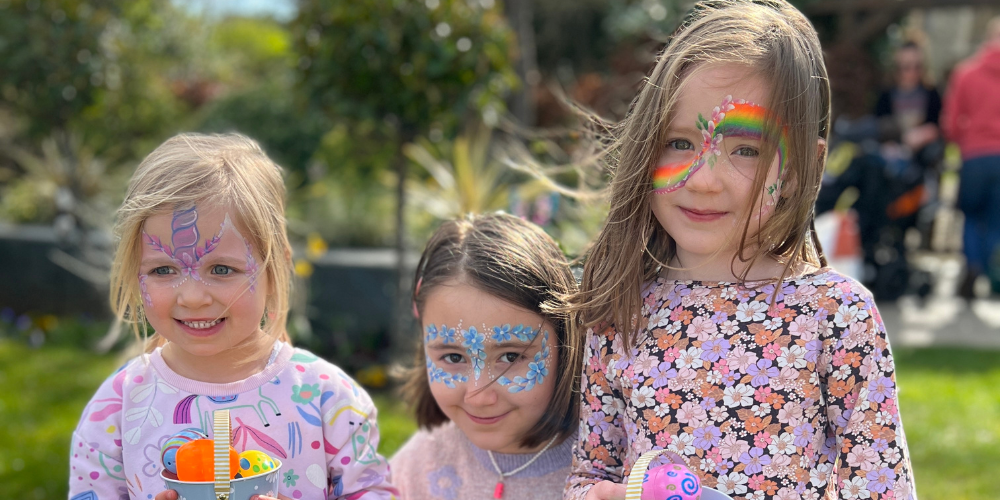 3 girls smiling with easter eggs in the garden