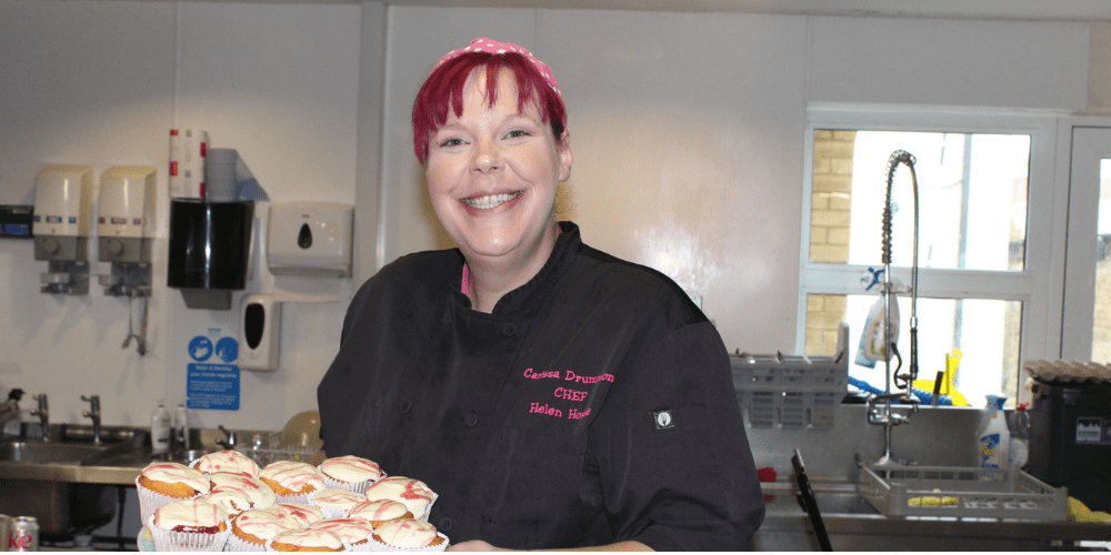 Chef Carissa smiling holding a plate of cupcakes