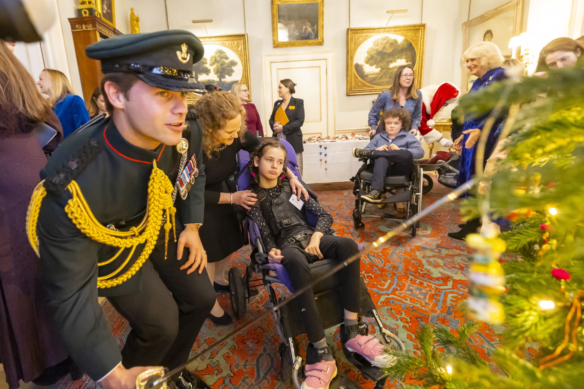 Equerry putting decorations on the tree with the Queen